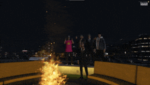 a group of people are standing around a fire in a video game with a screen that says evolution studios