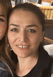 a close up of a woman 's face with two other women standing next to her .