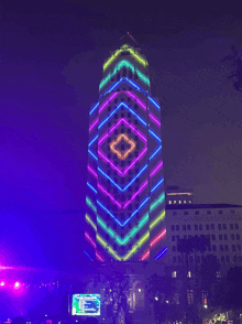 a large building is lit up at night with a geometric pattern on it