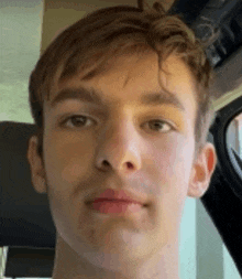 a young man is making a funny face in a car .