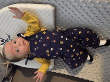 a baby in overalls is laying on a pillow that says ' a mo ' on it