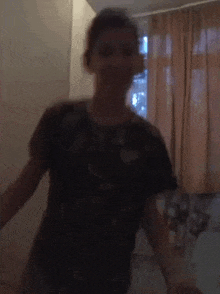 a blurry picture of a person dancing in a room with curtains .