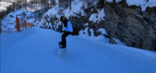 a person riding a snowboard down a snow covered hill