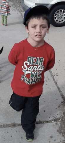 a boy wearing a dear santa was framed shirt