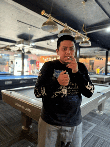 a man stands in front of a pool table that says legend billiard