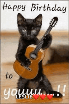 a black cat is holding a guitar in its paws on a birthday card