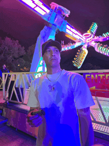 a man stands in front of a carnival ride that says enter on it