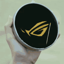 a person is holding a round container with a logo inside of it