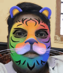 a man has his face painted to look like a rainbow colored tiger