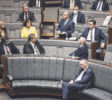 a man in a suit sits on a couch in a parliament