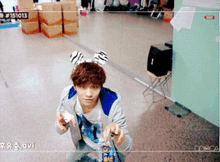 a boy wearing bunny ears is sitting on the floor in front of a mirror