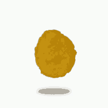 a fried chicken nugget is floating in the air on a white background .