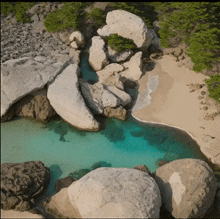 an aerial view of a rocky beach with blue water