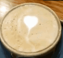 a close up of a cup of coffee with a heart shaped latte art on the top .