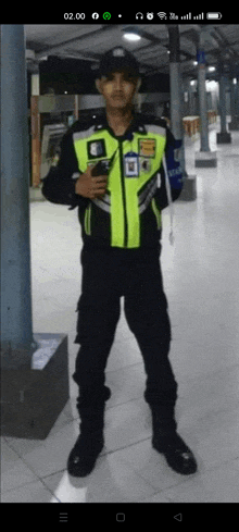 a man in a police uniform is holding a cellphone