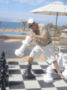 a man is playing a game of chess on a giant chess board