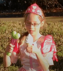 a little girl in a princess costume is holding an ice cream cone and a wand