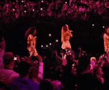 a crowd of people are watching two women singing on stage