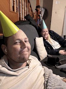 a man wearing a party hat is smiling next to a woman wearing a party hat