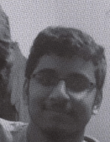 a close up of a man wearing sunglasses and a mustache in a black and white photo .