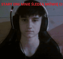 a young man wearing headphones with the words stary oni mnie sledza mowie on the bottom