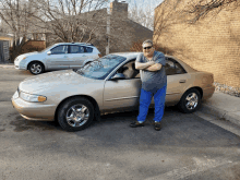 a man stands in front of a car that has the word buick on it