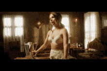 a woman in a white bra stands in a room