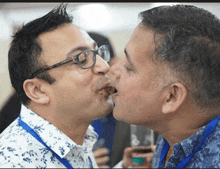 two men with glasses are kissing each other on the cheek