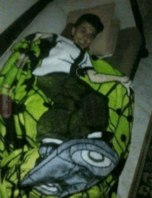 a boy laying on a bed with a blanket that has ben 10 on it