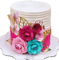 a pink and white cake with paper flowers and butterflies on top