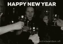 a black and white photo of a group of people toasting with wine glasses and the words happy new year