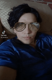 a man wearing sunglasses and a blue shirt has a tiktok account