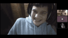 a boy wearing headphones is smiling in a video call with two other people