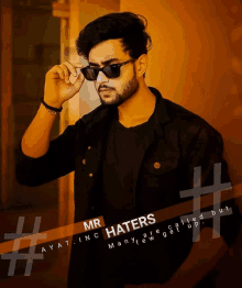 a man wearing sunglasses is standing in front of a wall with the caption mr haters many are called but ayat inc