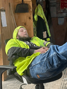 a man in a safety vest is sleeping in a chair