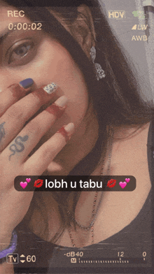 a woman with a tattoo on her finger is covering her face with her hand and a message that says lobh u tabu