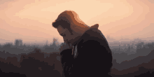 a man praying with his hands folded at sunset