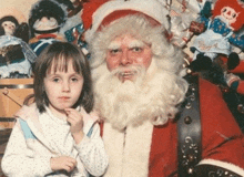 a little girl posing for a photo with santa claus