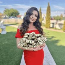 a woman in a red dress is holding a stack of money that says 100