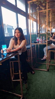 a woman sitting at a table with a cell phone