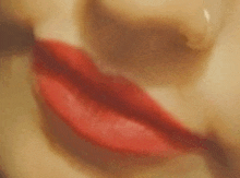 a close up of a woman 's lips with red lipstick .