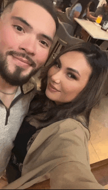 a man and a woman are posing for a picture in a restaurant