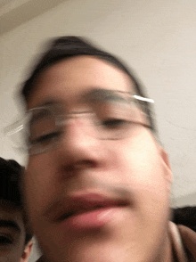 a blurry picture of a man 's face with glasses