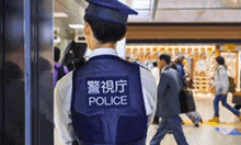 a police officer is standing in a crowded area .