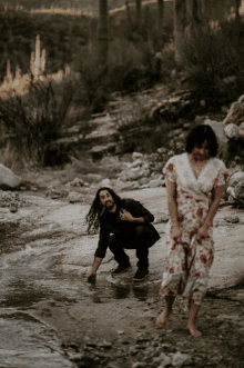 a man and a woman are playing in a stream of water