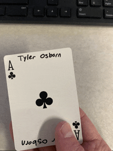 a person is holding a playing card with the name tyler osborn written on it