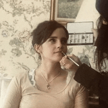 a woman is getting her makeup done by a woman in a room .