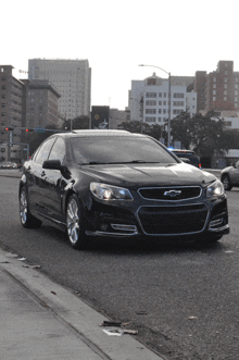 a black chevrolet is parked on the side of the street