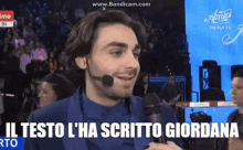 a man wearing a microphone with the words il testo l ' ha scritto giordana above him