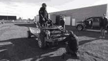 a black and white photo of a man working on a vehicle with a license plate that says ah - j - 784